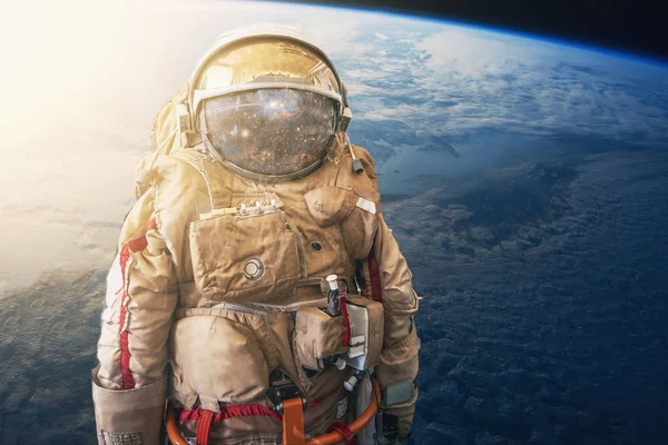 Космонавт или астронавт или космонавт в шлеме на фоне Земли из космоса. Элементы этого изображения предоставлены НАСА — стоковое фото
