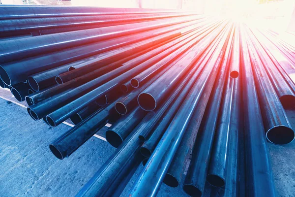 New metal pipes or tubes on construction site in sunlight and blue color, close up — Stock Photo, Image