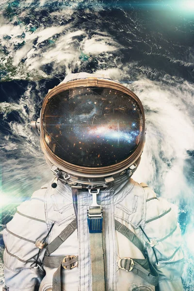 Космонавт или астронавт или космонавт в шлеме на фоне Земли из космоса. Элементы этого изображения предоставлены НАСА — стоковое фото