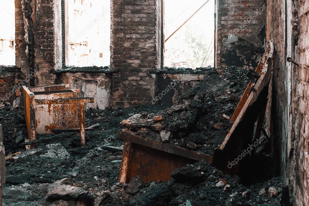 Burnt house interior. Burned room in industrial building, charred furniture and damaged apartment after fire