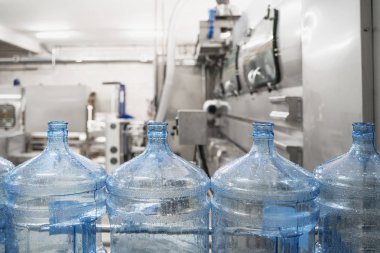 Saf su fabrikasında otomatik konveyör hattı veya bandı üzerinde mavi plastik şişeler