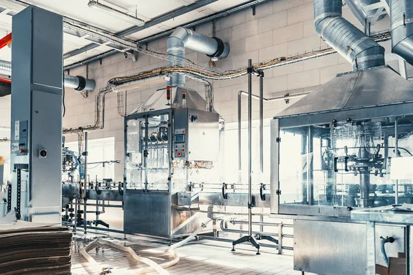 Workshop interieur met machines en transportband voor productie en bottelen van gezuiverd drinkwater in plastic flessen — Stockfoto