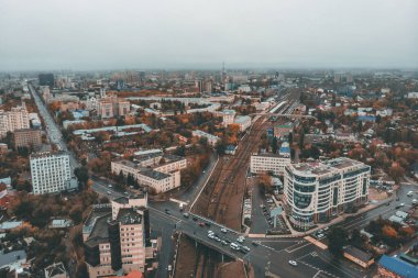 Sonbahar şehrinin üzerinde, sisli havada, birçok bina ve araba trafiği olan yollar üzerinde hava görüntülü uçuş.