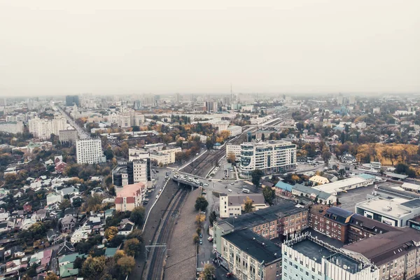 Luchtfoto cameravlucht boven de herfststad bij mistig weer met veel gebouwen en wegen met autoverkeer — Stockfoto