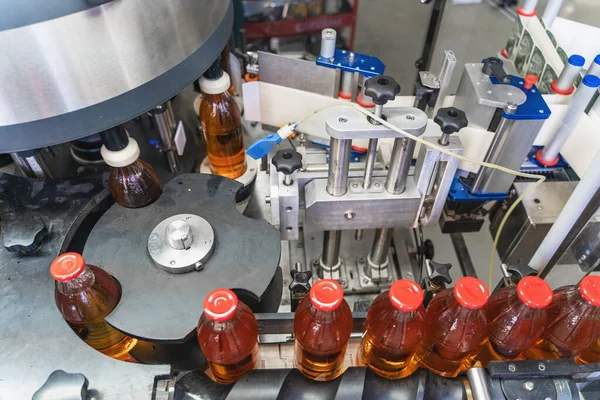 Cinta transportadora, jugo en botellas de vidrio en equipo de máquina automatizada en fábrica de bebidas — Foto de Stock