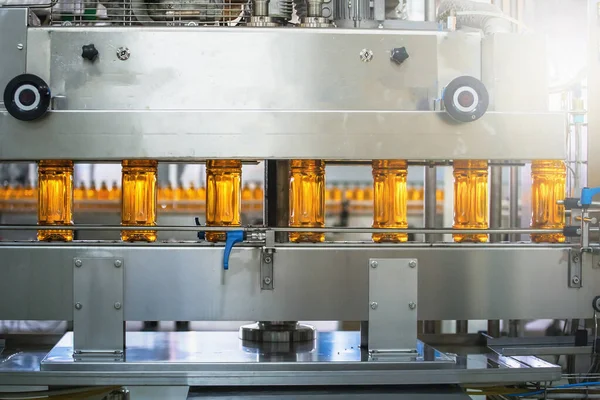 Línea transportadora con botellas de plástico de jugo en equipos modernos de fábrica. Interior de la planta de fabricación de bebidas — Foto de Stock