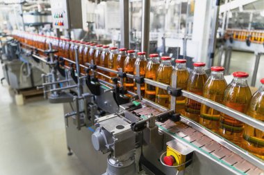 Conveyor belt, juice in glass bottles on beverage plant or factory interior, industrial manufacturing production line clipart