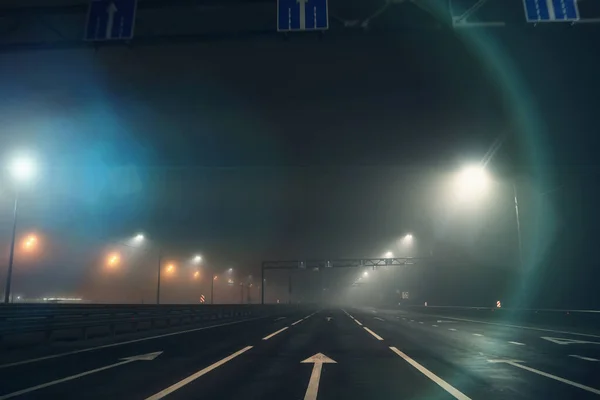 夜雾弥漫的街道或潮湿的沥青路和城市照明灯在秋天的雾气中，恐怖的气氛 — 图库照片