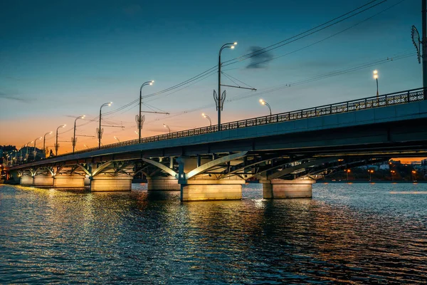 Voronezh por la noche paisaje urbano con puente Chernyavsky sobre el río con iluminación en el agua — Foto de Stock