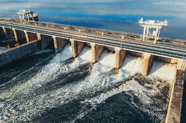 Hydroelectric dam or hydro power station at water reservoir, aerial view from drone. Draining water through gate, hydropower