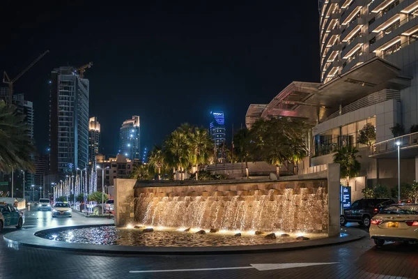 Dubai, Emiratos Árabes Unidos - febrero 2020: Vista nocturna de la fuente del hotel Dubai con iluminación, exterior moderno — Foto de Stock