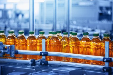 İçecek fabrikası, şişelerde meyve suyu bulunan taşıyıcı bant, mavi renkli endüstriyel içecekler, yiyecek ve içecek üretim hattı süreci.
