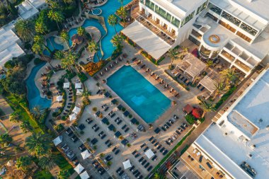 Deniz kıyısında havuzu olan otelin havadan görüntüsü, Kıbrıs tatil beldesinin yukarıdan drone fotoğrafı