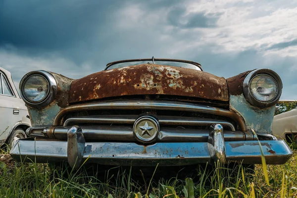 Oude retro roestige verlaten en vergeten auto, vooraanzicht — Stockfoto