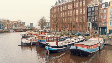 Hollanda 'nın tarihi merkezindeki Amsterdam su kanalında tipik bir yüzen ev