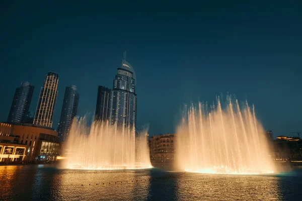 Dancing fountain show in Dubai center in evening, UAE. Tourist attraction