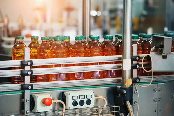 Jugo en botellas en cinta transportadora, interior de la fábrica de bebidas, línea de producción industrial —  Fotos de Stock