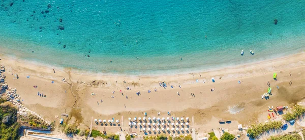 Aerial top view panorama of beautiful Coral beach in Paphos with azure seawater, Cyprus. Sand coast with umbrellas, sunbeds, people and clear sea water — Stock Photo, Image