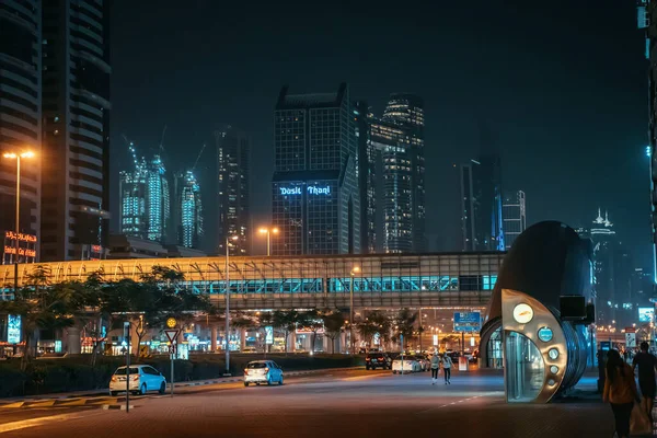 Dubai, Emirados Árabes Unidos - Fevereiro 2020: Dubai centro da cidade à noite com edifícios modernos, rua e travessia de pedestres, Emirados Árabes Unidos — Fotografia de Stock