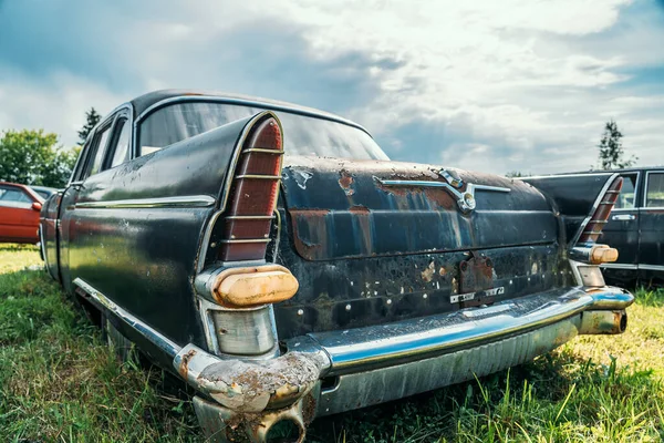 Oude verlaten roestige auto roesten op groen gras — Stockfoto
