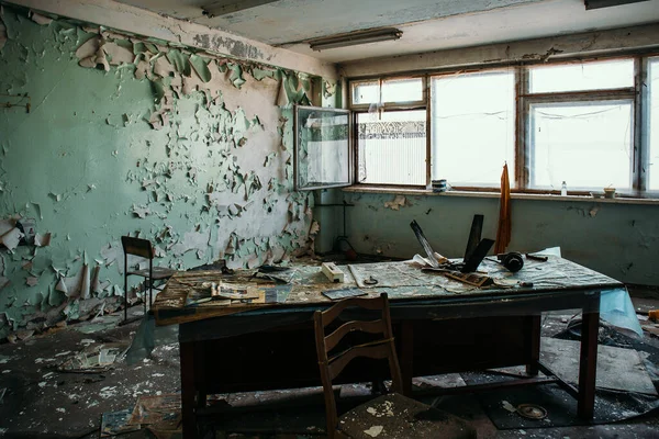 Inquietante stanza ufficio abbandonata all'interno con vecchio tavolo in legno e finestre. Concetto di orrore — Foto Stock