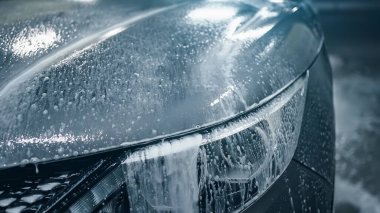 Oto Yıkama, birinci fazın aktif temizlik köpüğü kaputtan aşağı süzülüyor.