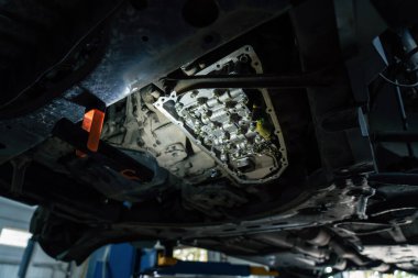 CVT şanzımanı kapanıyor, Araç Servisi 'ndeki SUV' nin modern otomatik şanzımanında yağ değiştiriliyor.