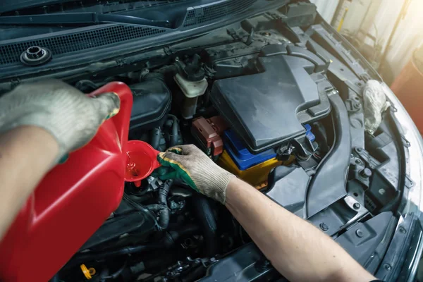 Menuang minyak mesin baru dari tabung ke corong motor di layanan mobil, menutup — Stok Foto