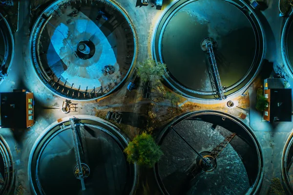 Vista aérea nocturna de la moderna planta de tratamiento de aguas residuales con piscinas redondas para la limpieza de aguas residuales, tiro con drones —  Fotos de Stock