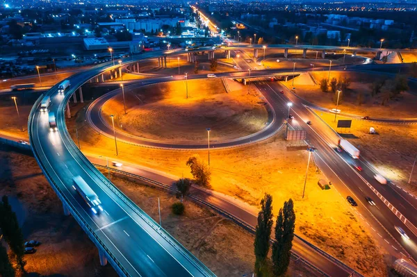 Intersection transport junction at night city road with bridges and car traffic, aerial view — Stock Photo, Image