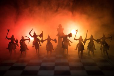 Süvari ve satranç tahtası üzerinde piyade ile ortaçağ savaş sahnesi. Satranç oyununu kavramı iş fikirleri ve rekabet ve strateji fikirler duman ve sis karanlık bir arka plan üzerinde satranç figürleri.