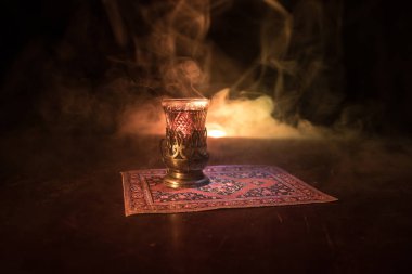Geleneksel glasse ve ışıklar ve duman siyah zemin üzerine pot Doğu tea. Doğu çay kavramı. Armudu geleneksel Azerbaycan/Türkiye Kupası. Seçici odak. Bardak çay