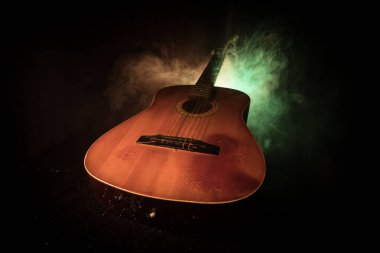 Müzik konsepti. Akustik gitar duman ile ışık altında karanlık bir arka plan üzerinde. Gitar dizeleri ile kapatın. Seçici odak. Yangın etkileri.