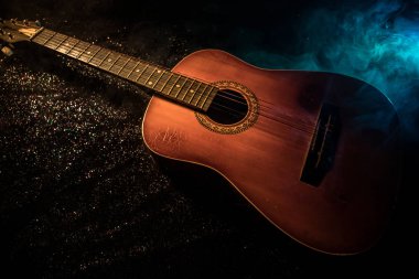 Müzik konsepti. Akustik gitar duman ile ışık altında karanlık bir arka plan üzerinde. Gitar dizeleri ile kapatın. Seçici odak. Yangın etkileri.