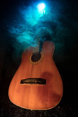 Müzik konsepti. Akustik gitar duman ile ışık altında karanlık bir arka plan üzerinde. Gitar dizeleri ile kapatın. Seçici odak. Yangın etkileri.