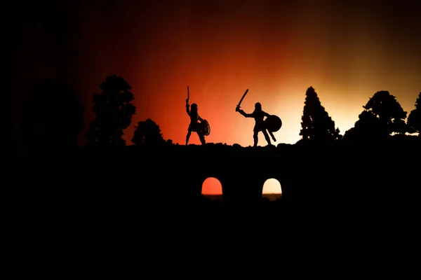 騎兵と歩兵と橋に中世の戦闘シーン 個別のオブジェクトとして人物のシルエットは 暗いトーンの霧の背景に戦士の間戦います 夜のシーン 選択と集中 — ストック写真