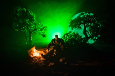 Yağmurluk ile onun el kavramı içinde parlayan fener karanlık ormanın gelen adam. Lamba korku katille silüeti. Dekorasyon