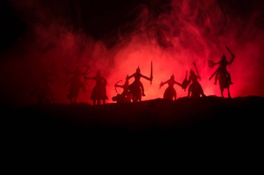 Süvari ve piyade ile ortaçağ savaş sahnesi. Siluetleri şekiller ayrı nesneler olarak mücadele koyu tonda sisli arka plan savaşçılar arasında. Gece sahne. Seçici odak