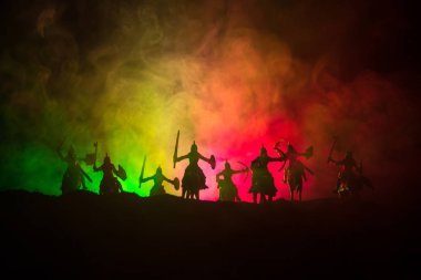 Süvari ve piyade ile ortaçağ savaş sahnesi. Siluetleri şekiller ayrı nesneler olarak mücadele koyu tonda sisli arka plan savaşçılar arasında. Gece sahne. Seçici odak