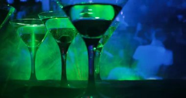 Ünlü kokteyl Martini, birkaç bardak koyu tonda sisli arka plan ve disko ışıkları ile bir barda vurdu. Club içki kavramı. Seçici odak