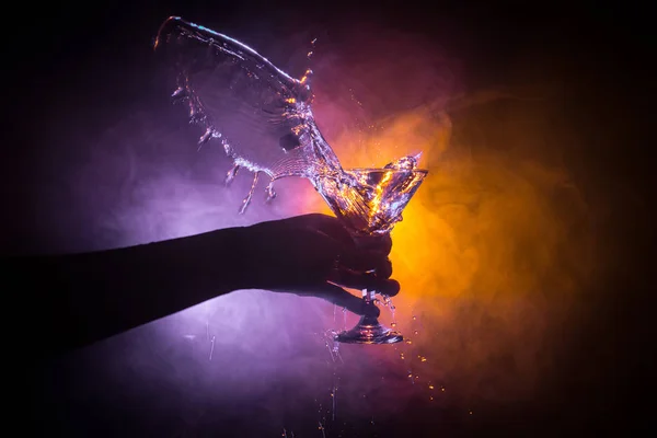 マティーニ カクテル グラスを手に暗いトーン スモーキーな背景やガラスの飛散とオリーブではカラフルなカクテルにはね パーティー プールクラブ エンタテインメント 混合光 選択と集中 — ストック写真