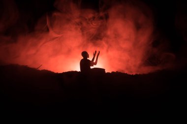 Sisli arka planda dua eden Müslüman adamın silueti. Ramazan Kareem geçmişi. Müslüman bayramı dekorasyonu. Dua eden insanlar din kavramı. Seçici odak