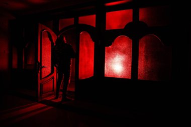 Kapalı cam bir kapıdan geçen, bilinmeyen bir gölge figürünün silueti. Geceleri pencerenin önündeki bir insanın silueti. Manyağın bulanık silueti korkunç cadılar bayramı konsepti.