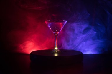 İçinde zeytin olan martini bardağı. Koyu sisli arka planda kulüp içkisi olan cam manzarasını kapat. Seçici odaklanma. Kulüp içki konsepti