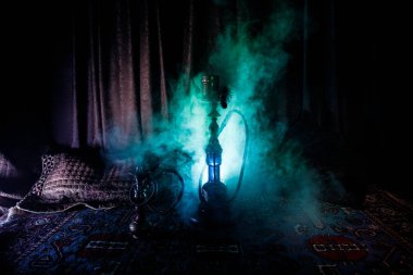 Nargile kömürü nargile kupa Arap iç de buhar bulutları yapma. Şark süsleme halı üzerinde. Şık oryantal shisha içinde karanlık arka ışık ile. Shisha reklam için. Seçici odak