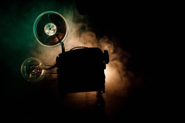 Eski stil film projektör, Natürmort, yakın çekim. Film projektör dramatik aydınlatma ve seçici odak ahşap bir zemin üzerine. Film ve eğlence kavramının