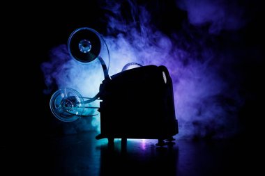 Eski stil film projektör, Natürmort, yakın çekim. Film projektör dramatik aydınlatma ve seçici odak ahşap bir zemin üzerine. Film ve eğlence kavramının