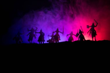 Süvari ve piyade ile ortaçağ savaş sahnesi. Siluetleri şekiller ayrı nesneler olarak mücadele koyu tonda sisli arka plan savaşçılar arasında. Gece sahne. Seçici odak