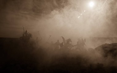 Süvari ve piyade ile ortaçağ savaş sahnesi. Siluetleri şekiller ayrı nesneler olarak mücadele günbatımı sisli arka plan savaşçılar arasında. Seçici odak