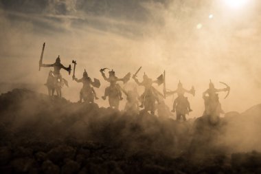 Süvari ve piyade ile ortaçağ savaş sahnesi. Siluetleri şekiller ayrı nesneler olarak mücadele günbatımı sisli arka plan savaşçılar arasında. Seçici odak